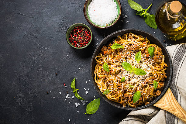 istock Pasta Bolognese in the skillet at black table. 2226496072