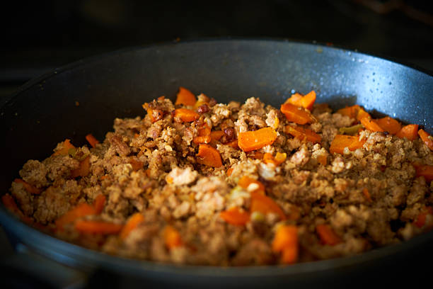minced vegetables and meat are fried in a frying pan
