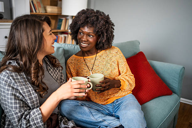 istock Two female friends relaxing on sofa, drinking tea and chatting 2226497536