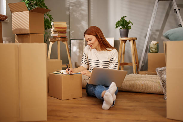 istock Woman organizing her move to new home using laptop 2226498240