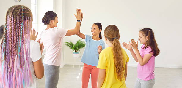 istock Friendly female choreographer gives high five to her students after successful dance lesson. 2226506162