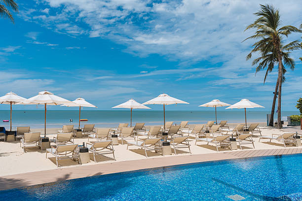 istock Beachfront resort with poolside, lounge chairs and white parasol on sunny day 2226508466
