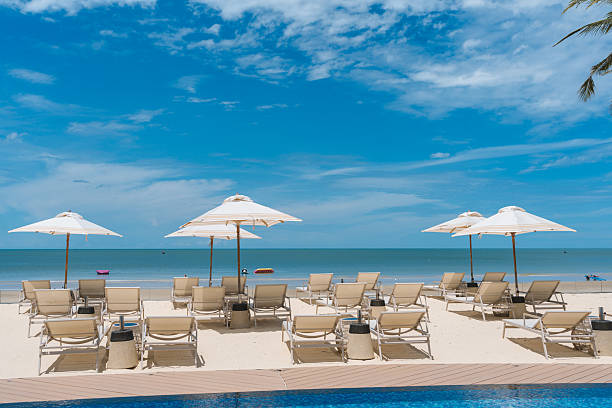 istock Beachfront resort with poolside, lounge chairs and white parasol on sunny day 2226508472