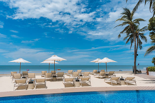 istock Beachfront resort with poolside, lounge chairs and white parasol on sunny day 2226508473