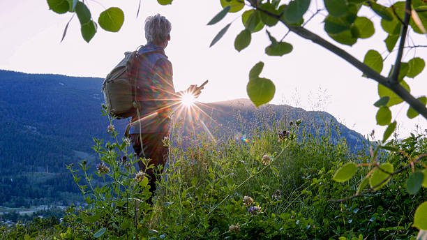 istock Mature man uses mobile phone in mountain meadow 2226513768
