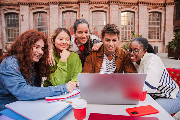 istock Enthusiastic Students Collaborating on a Laptop While Studying Together and Sharing Ideas in a Bright and Engaging Learning Environment Surrounded by Friends and Classmates at Their University Campus 2226515256