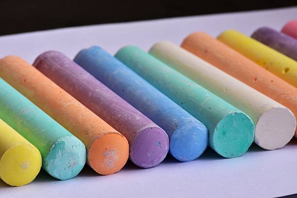 istock Side angle view of large pastel chalk sticks arranged in neat rows. Artistic texture and vibrant colors represent creative expression, school supplies, and children drawing tools. 2226516559