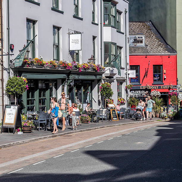 View along a main street in the centre of Tenby, Pembrokeshire, UK.  People can be seen on the promenade