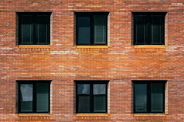 istock Simple brick apartment wall with symmetrical black-framed windows 2226518497
