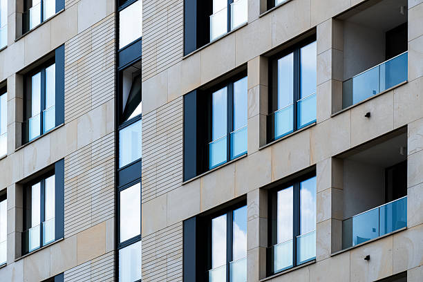 istock Stylish urban apartment building with beige cladding and vertical glass sections 2226518709
