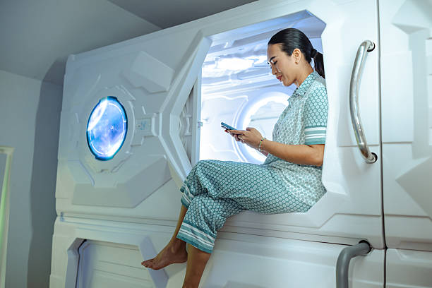 istock Woman relaxing in modern pod using smartphone in comfortable pajamas 2226519141