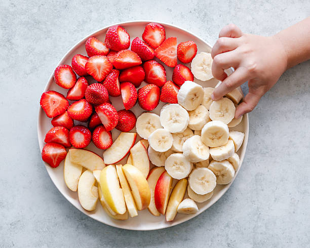 Bananas are arranged inside a bamboo basket decorated with some fresh green leaves. Banana (Musaceae) will protect the body from damage caused by the oxidation of free radicals
