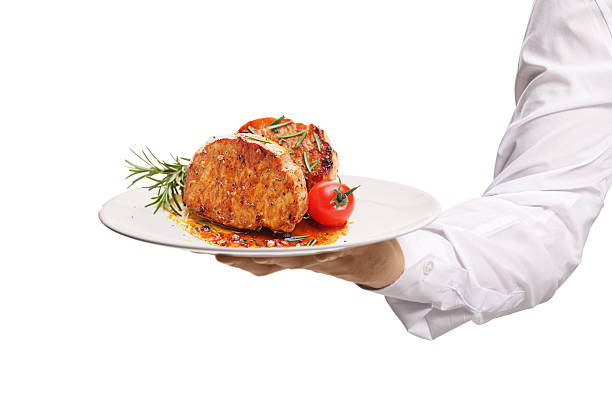 istock Male hand holding a plate with cooked steak 2226528232