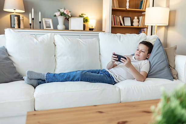 istock Caucasian child, streaming and smartphone for educational games, growth and development in home. Kids, mobile tech and sports for creativity, fun and social media with application, download and playing. 2226530664