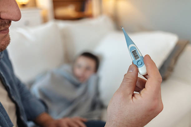 istock Cropped shot of a man checking his son's temperature. 2226530991