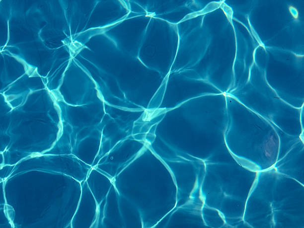 Sunlit Water Reflections Turquoise swimming pool surface with soft sun reflections creating relaxing summer atmosphere perfect for travel content wellness branding resort visuals and tropical vacation themed backgrounds