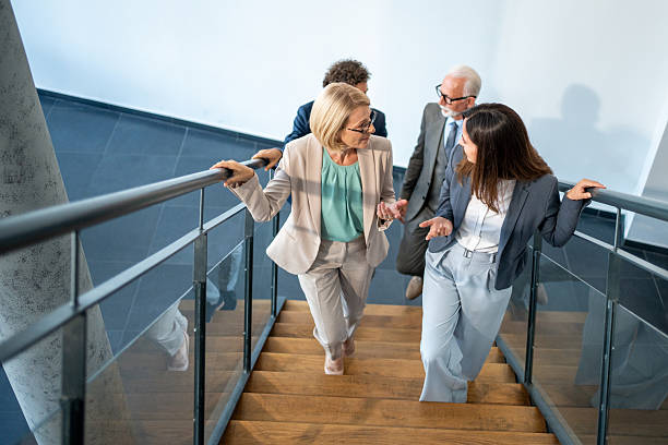 istock Business people walking down stairs in modern office building 2226534831