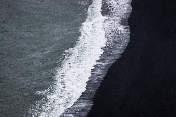 istock Waves separating dark ocean and black earth 2226536454