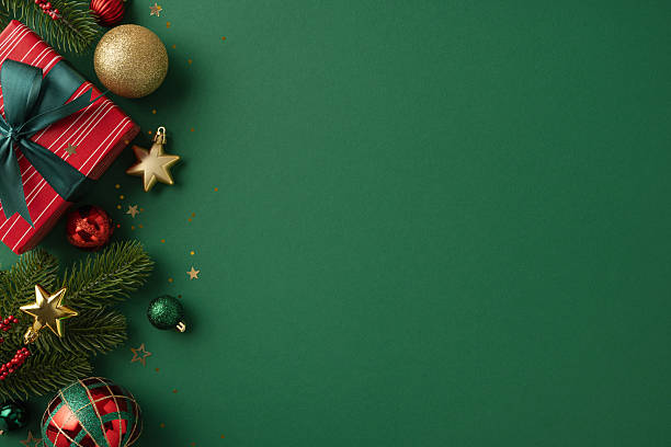 istock Festive Christmas flatlay featuring wrapped gift, ornaments, and greenery against a green backdrop 2226536788