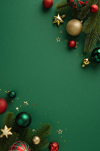 istock Christmas vertical ornaments, including baubles and stars, arranged on a green background with pine branches and glitter accents, evoking holiday spirit and seasonal joy. 2226536794