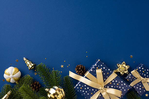 istock Christmas-themed arrangement featuring presents, ornaments, and greens on a bold blue surface 2226536804