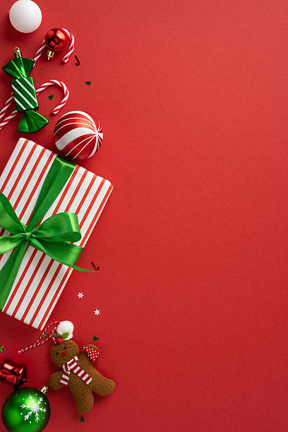 istock Vivid vertical red Christmas background featuring a wrapped gift, ornaments, candy canes, and decorations 2226536822