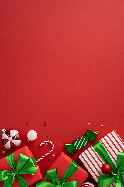 istock Festive red vertical background featuring Christmas presents, ornaments, and decorations with green details. Perfect for holiday themes, gift exchanges, and seasonal celebrations 2226536833