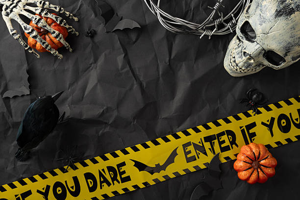 istock Halloween-themed still life featuring a skull, skeleton, pumpkins, caution tape, and spooky props 2226536860