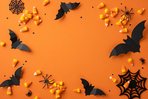 istock Halloween-inspired design featuring candy corn, black bats, and spider webs on an orange surface creating a festive layout 2226536862