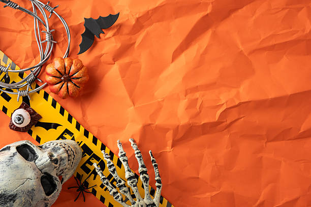 istock Halloween-themed props, including a skull, skeleton hand, and pumpkin on a festive backdrop 2226536863