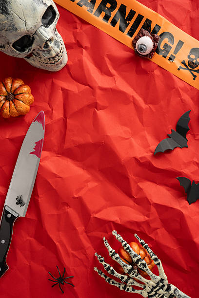 istock Intricate vertical setup of spooky Halloween objects including a skull, knife, skeleton hand, and decorations 2226536866