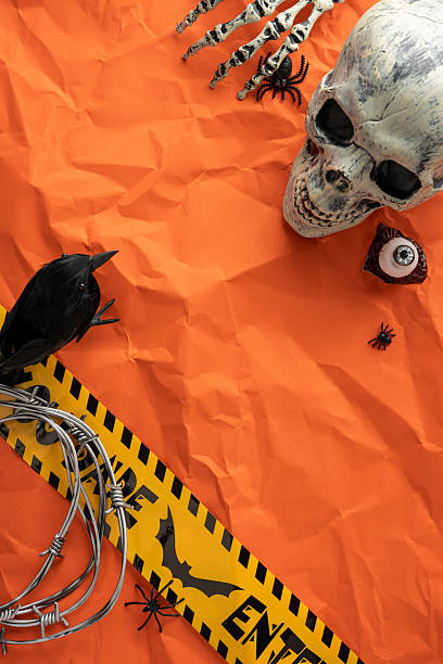 istock Spooky vertical Halloween-themed setup featuring a skull, barbed wire, and warning tape on orange 2226536882