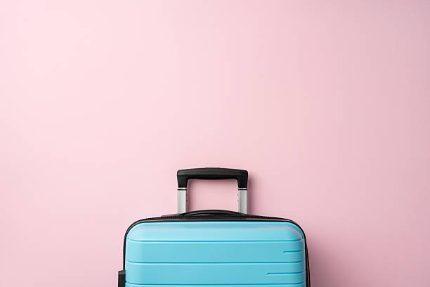istock Minimalist composition featuring a light blue suitcase on a soft pink backdrop, evoking travel vibes 2226536890