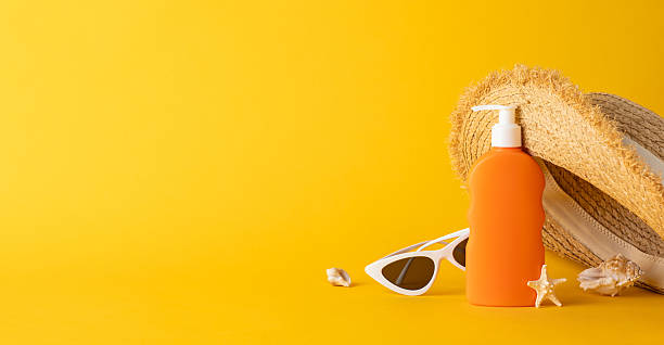 istock Summer essentials including a sunscreen bottle, straw hat, and sunglasses on a vivid yellow surface creating a bright and sunny atmosphere 2226536909