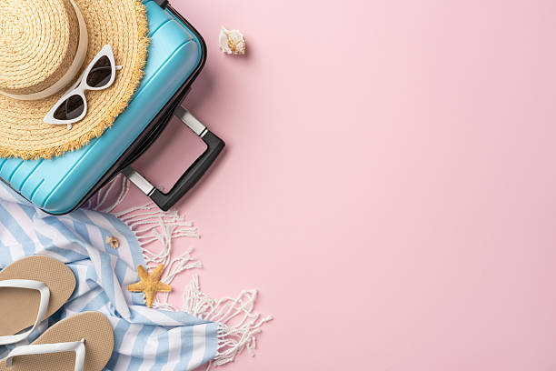 istock Flat lay of vacation items including blue suitcase, sunglasses, hat, and beach essentials 2226536916