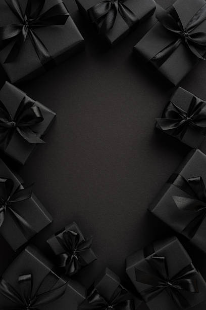 istock Elegant black vertical wrapped gift boxes with ribbons placed on a sleek dark surface 2226536943