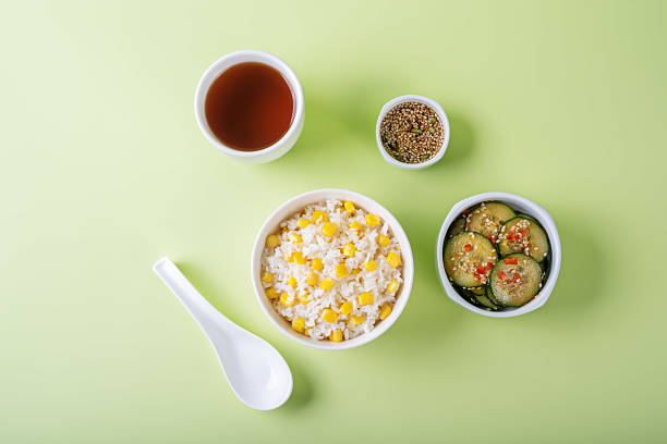 Asian corn rice in a bowl with cucumber salad. toning