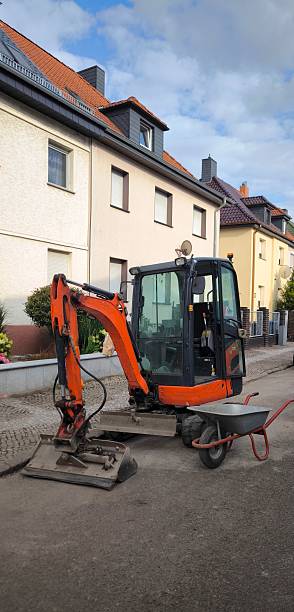 istock Orange mini excavator and construction wheelbarrow at repair work 2226538961