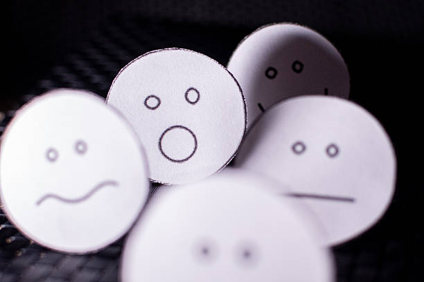 Drawing of a happy smiling emoticon on a yellow paper and white background.