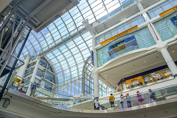 Toronto, Canada - July 13, 2025: Interior view of the CF Toronto Eaton Centre featuring glass ceilings and shoppers on upper and lower levels.