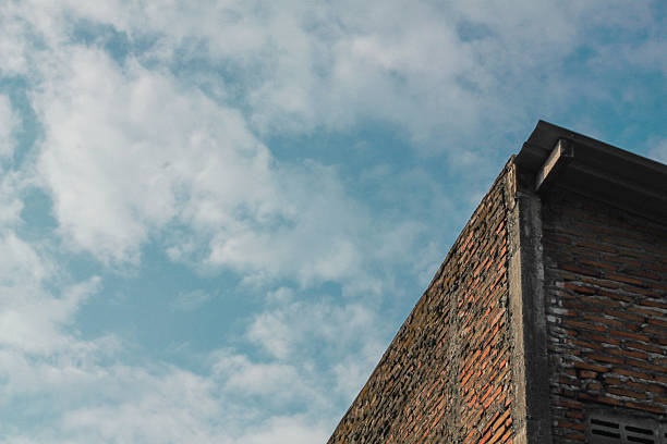 istock corner of a brick building under a beautiful blue sky filled with fluffy white clouds. 2226546904