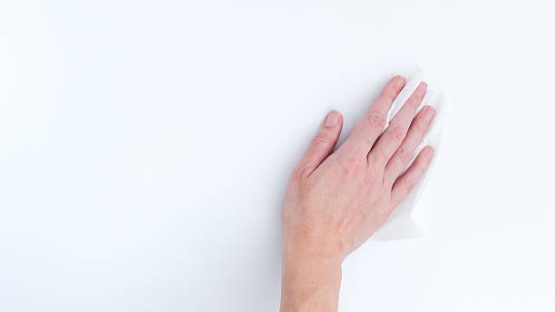 istock Hand Wiping Clean a White Background Surface, Promoting Hygiene and Disinfection Practices. 2226548007