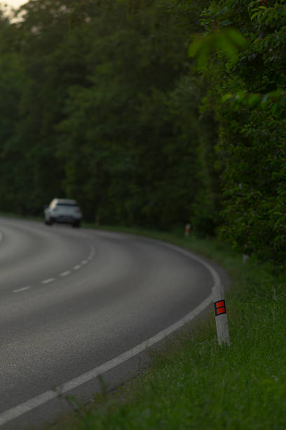 istock A car is driving down a curvy road that winds through the woods 2226548333