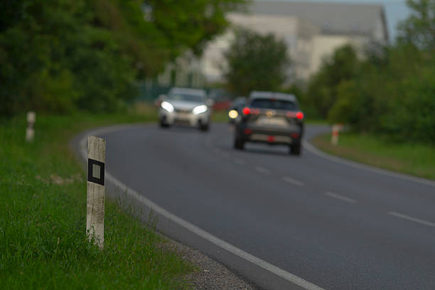 A slightly unclear image captures several cars driving down a country road