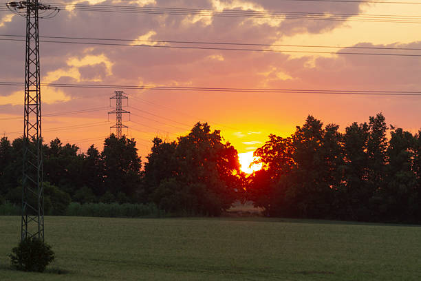 A stunning sunset featuring a prominent telephone pole positioned in the foreground, creating a captivating contrast against the vibrant sky