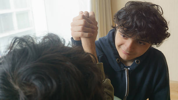 Face of a young man playing arm wrestling