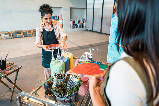 istock Young Middle Eastern Art Students In Aprons Mixing Paint Colors During Creative Workshop Session 2226555667