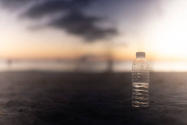 Close-up of a plastic water bottle in the sand on the beach