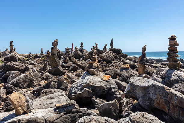 istock Balanced stone towers on rocky coastal cliffs overlooking the Atlantic Ocean under a clear blue sky in Portugal. 2226557509