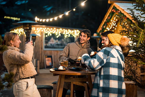 istock Joyful Couples Enjoying Drinks in Festive Winter Wonderland 2226557568